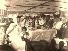 EH01A - Repas sur un remorqueur du chantier, Daddy est à droite, 2 des enfants sont à gauche, autour d'une des demoiselles Quaintaine, amies de Nanny
